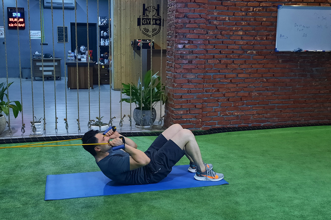 شکم کرانچ با کش از بالا سر خوابیده