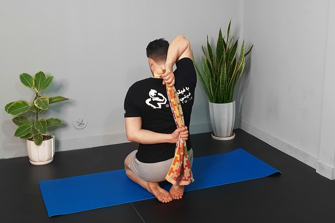 کشش پشت بازو با حوله پشت سر نشسته