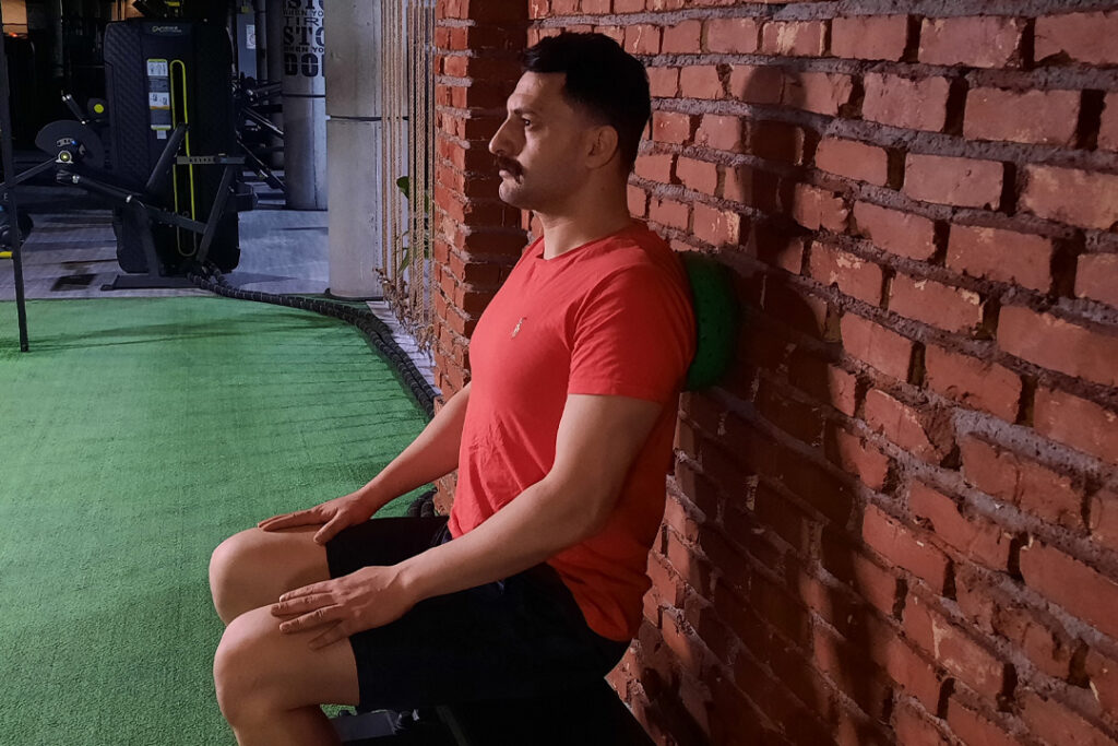 فشار ایزومتریک به توپ بین کتف‌ها و دیوار نشسته