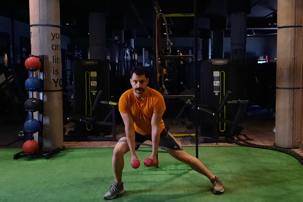 لانجز به پهلو باتراباند دور ران با دمبل در دست