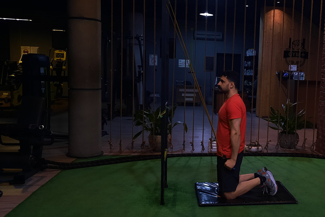 پشت بازو با کش روی زانو نشسته